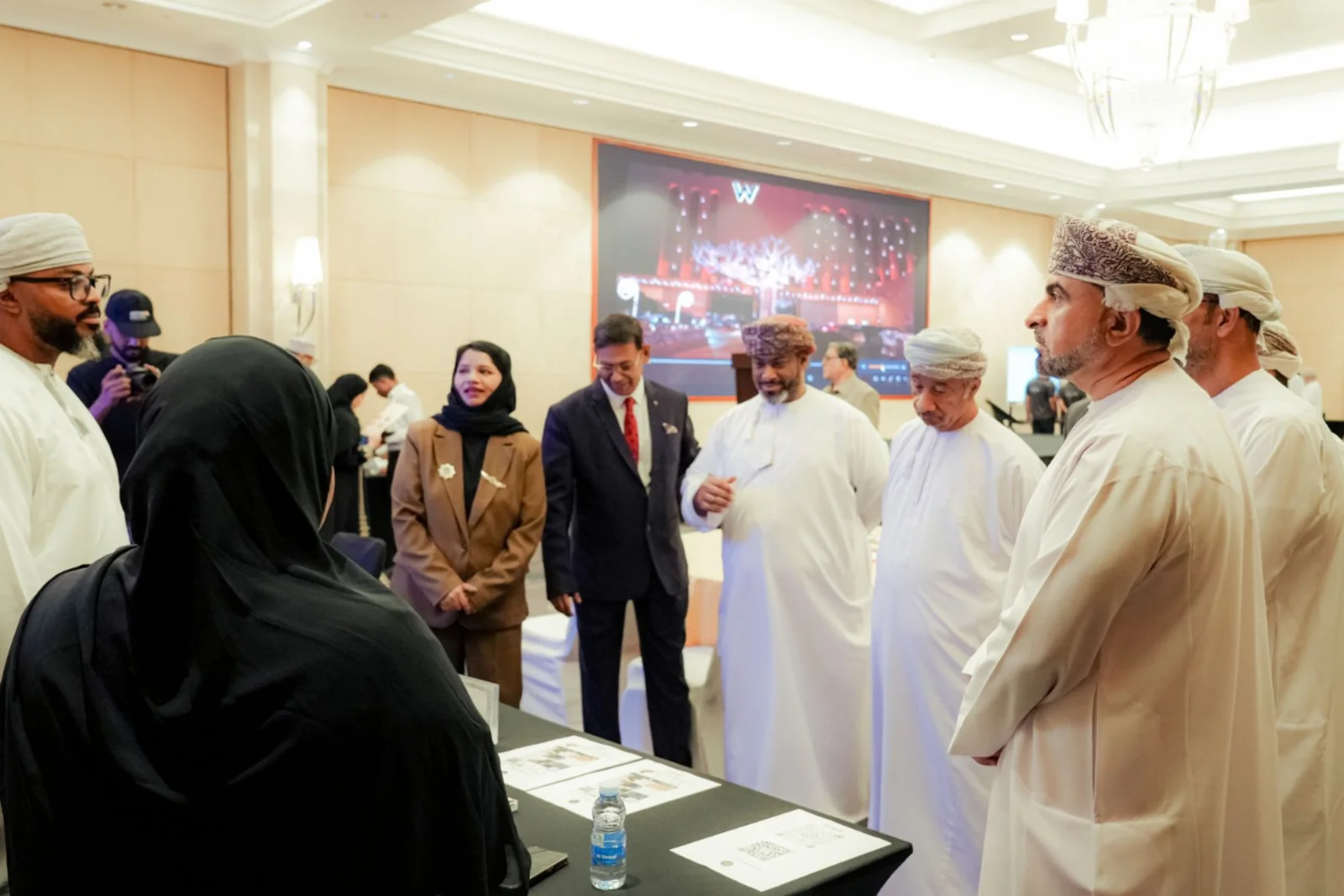 Business Carnival attendees gathered in conversation around an exhibition table