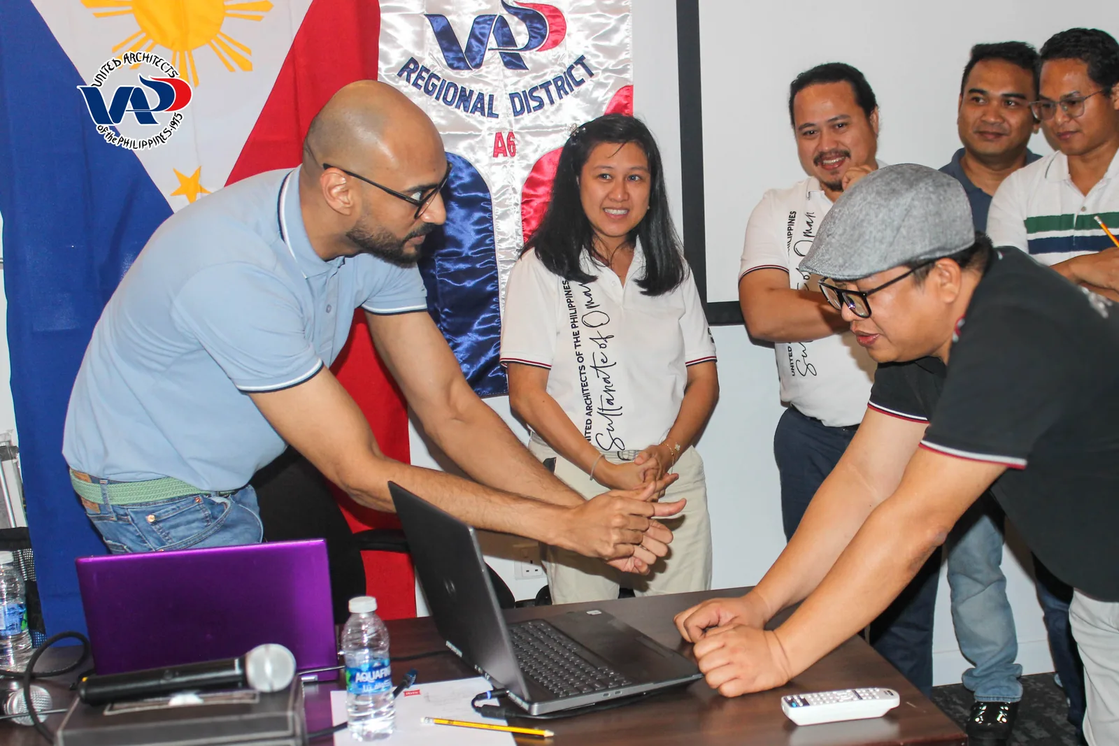 Workshop participants gathered around a laptop during an exercise